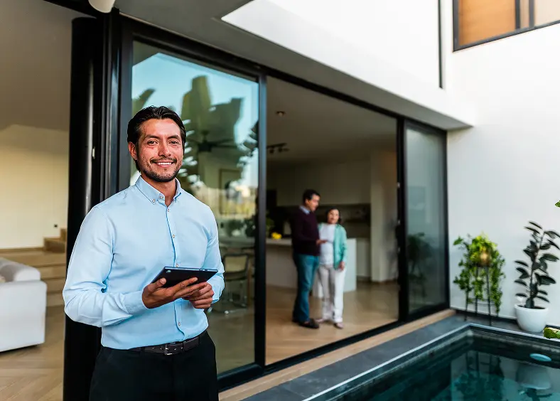 Man smiling by pool with tablet.